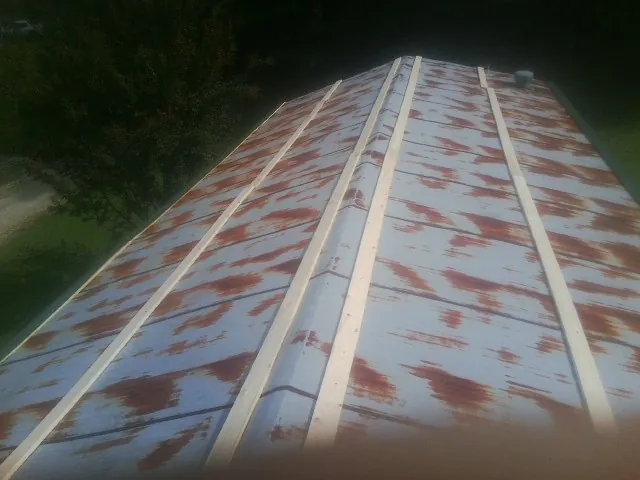 Rusted metal roof panels with new wood purlins before replacement — Storm Damage Roof Repair in Hendersonville by Roofing Brothers
